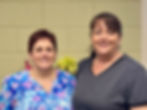 A picture of two women standing and smiling for the camera
