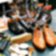 Picture showing 3 pairs of recrafted shoes on a workstation with tools and brushes