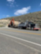 excavator being loaded onto the flat bed truck