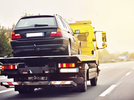 Flatbed tow truck carrying a car for towing in Montreal