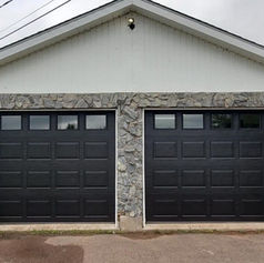 A stone-clad garage with wooden doors