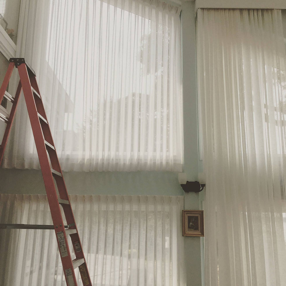 A brown staircase kept next to large windows covered with plastic curtains.