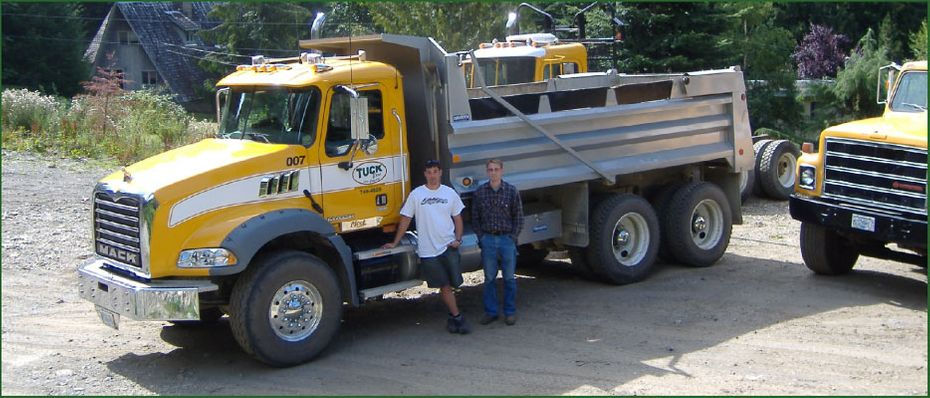 Owners Standing Next to Dump truck