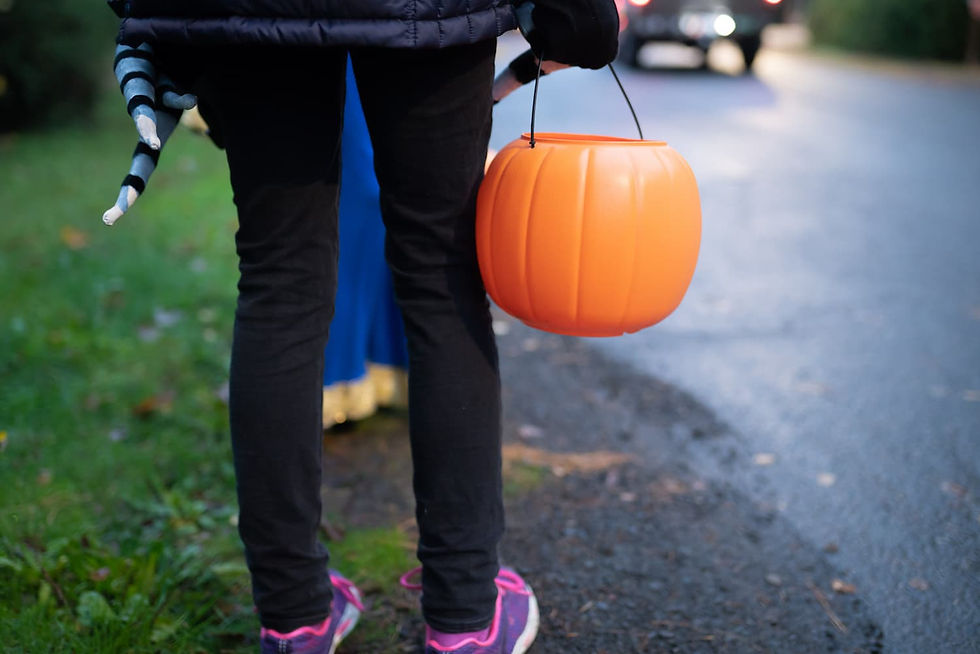 Kid trick or treating on halloween near cars