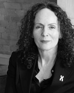 Fiona McAnena, author of Terf Island and policy expert at Sex Matters, seated indoors for a black-and-white portrait wearing a dark blazer with a Sex Matters lapel pin.