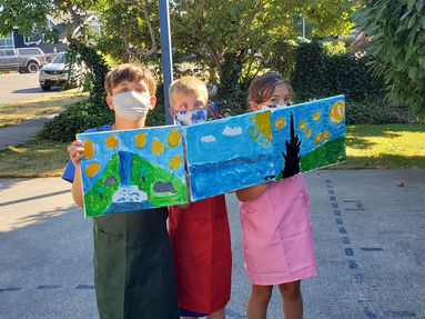 afterschool art program students holding their artwork