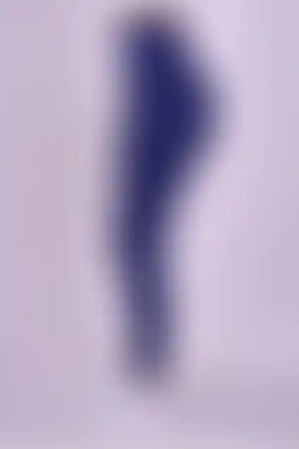 Kadın koyu lacivert tayt, spor ayakkabı ile birlikte gösteriliyor.