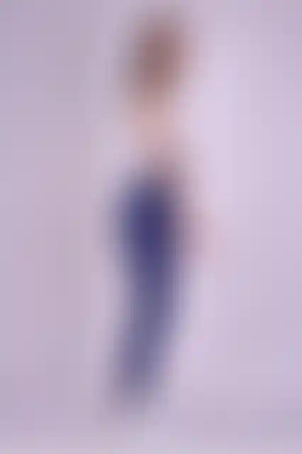 Kadın, lacivert tayt ve beyaz spor üstüyle poz veriyor