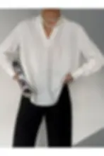 Beyaz çizgili bluz, inci kolye, siyah pantolon