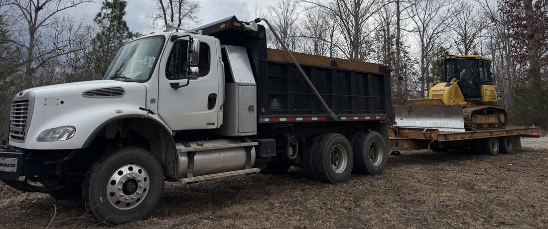 Dump truck hauling stone and fill dirt for a grading project