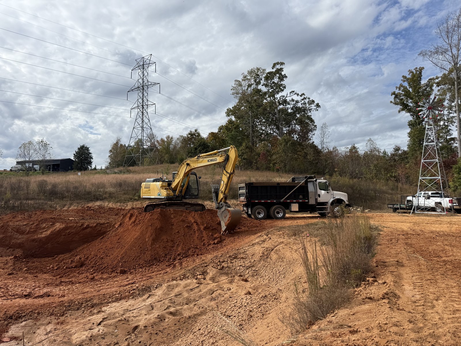 Excavator digging a pond on residential acreage