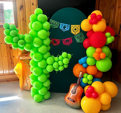 Fiesta first birthday balloon installation with vibrant colorful balloons, a balloon cactus sculpture, emerald green Chiara l