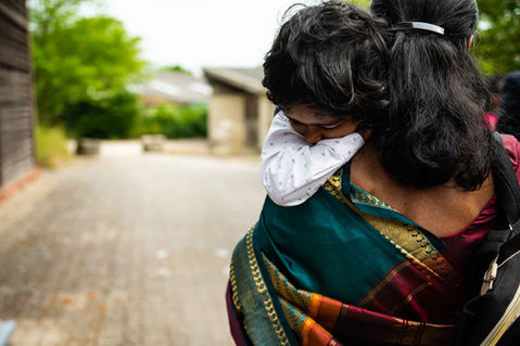 Young boy carried by his mother wearing traditional Sri Lankan clothing