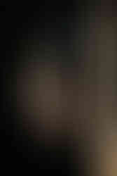 Kontrastreiches Streetfoto, 2 Menschen gehen zwischen Säulen.