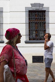 Menschen vor weißer Hausfassade.