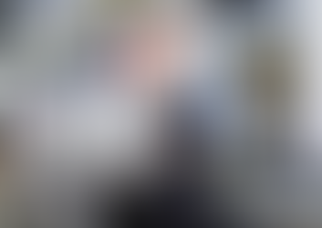 Smiling Female Hairdresser and Retail Assistant holding bottle of shampoo for sale