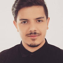 Homem branco, cabelo e barba preta, camisa preta.