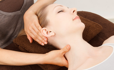 A woman having her neck and shoulders massaged