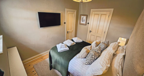 Overhead view of luxury double room with television, plush bedding, and serene tones — part of Parsonstown Estate’s boutique accommodation in Meath.
