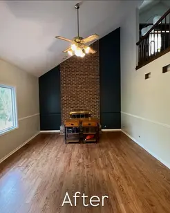 Updated living room with freshly painted fireplace accent wall and trim