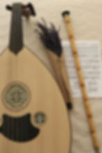 Traditional Sufi instruments including a beautifully crafted oud and a ney, accompanied by sheet music and a bouquet of lavender, evoke an atmosphere of serene spiritual music.
