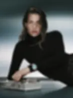 A close-up of Charlotte de Witte adjusting an analog synthesizer. On her wrist, a stainless steel Tudor watch featuring a turquoise blue dial. The image announces her role as a Tudor brand ambassador for Mixmag News