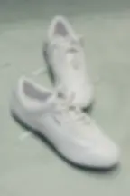 Pair of all-white Puma x Jil Sander leather sneakers featuring minimal design and subtle Jil Sander logo branding