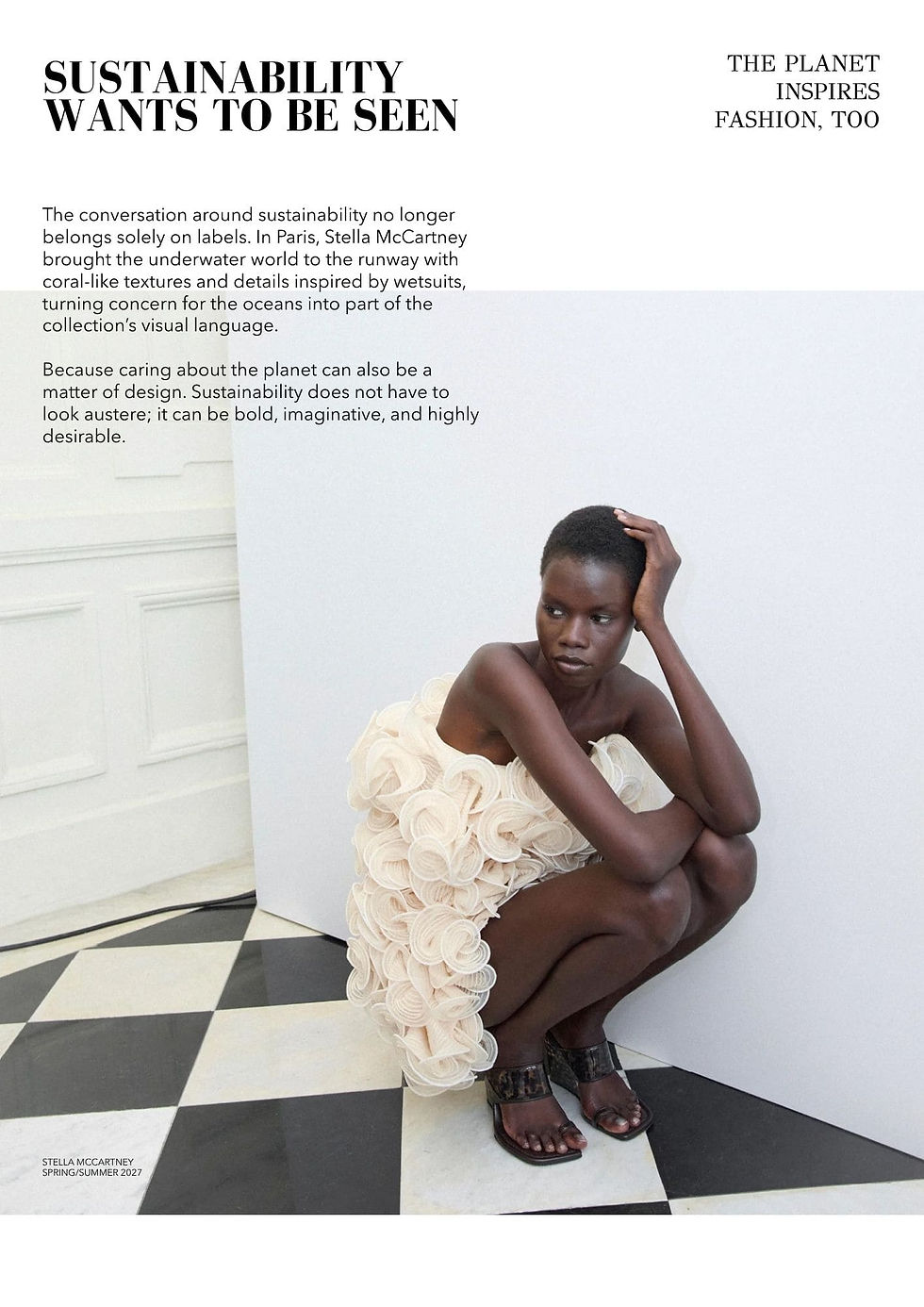 Model posing on the floor in a white mini dress with three-dimensional circular textures inspired by sea corals from Stella McCartney's eco-friendly collection
