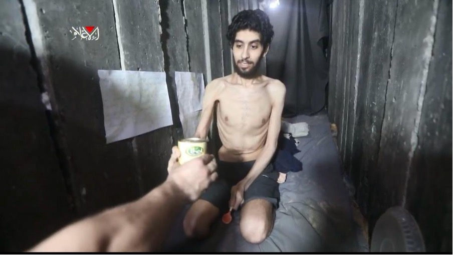 Starving hostage Evyatar David in a video released by Hamas. The arm of the Hamas captor, much larger than Evyatar’s, indicates that Hamas purposely starves the hostages. | Source: Israel Foreign Ministry on X