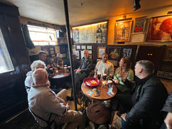 Group of people at a pub, drinking, talking, and enjoying their time