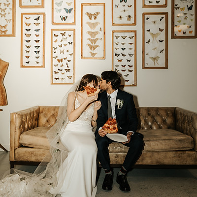a couple eating pizza at their wedding
