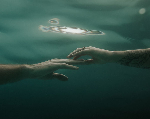 hands underwater with a wedding ring