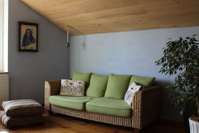 Blaue Wand mit grünem Sofa zur Stärkung des entsprechenden raumpsychologischen Bereichs, der für Ruhe und Ausgeglichenheit sorgt.