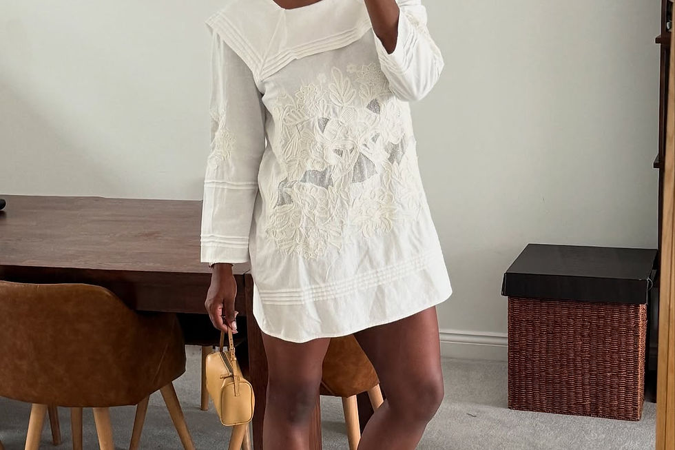 Black mesh Mary Jane flats with a white dress, strap visible