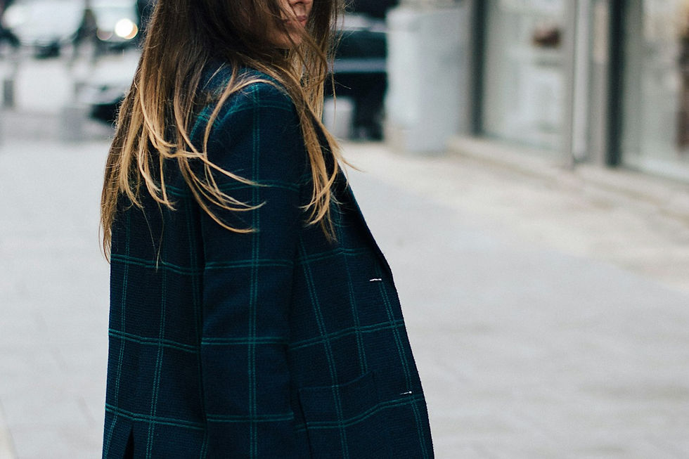 Woman in a plaid wool coat on a city sidewalk