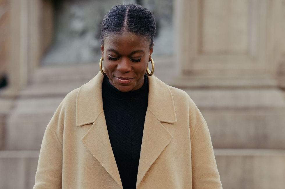 Camel wool coat worn open over a black turtleneck