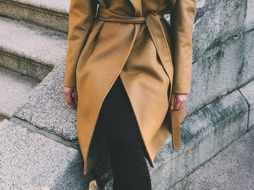 Woman in a camel wool coat with the belt tied, length past the hip