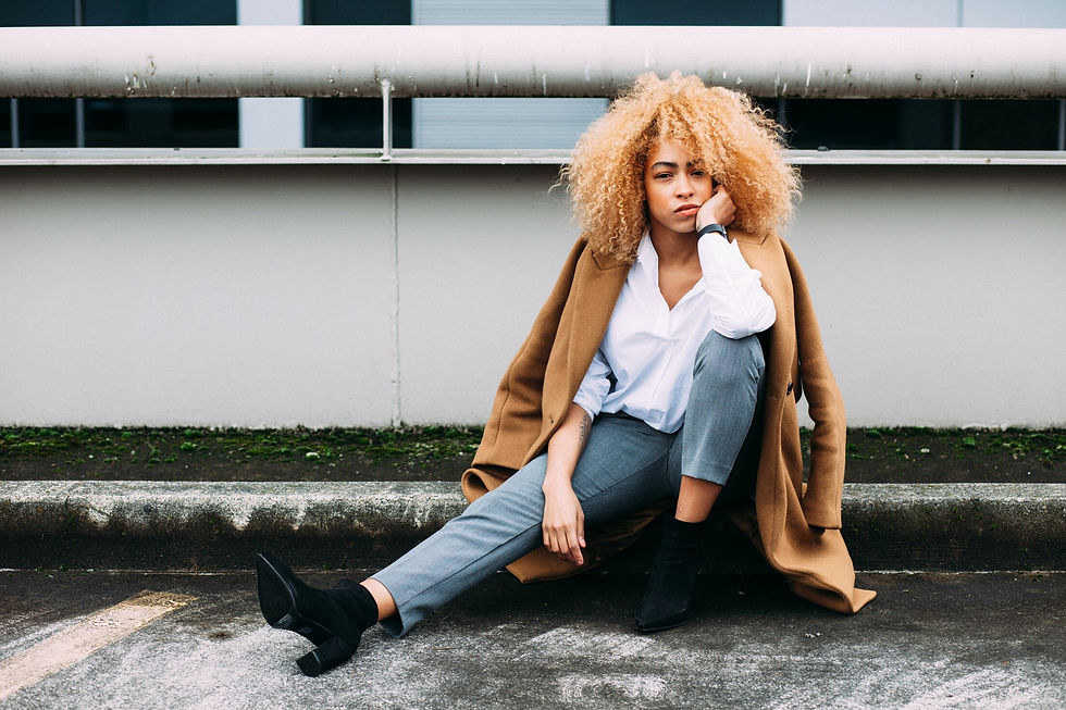Camel wool coat over a white shirt and grey trousers