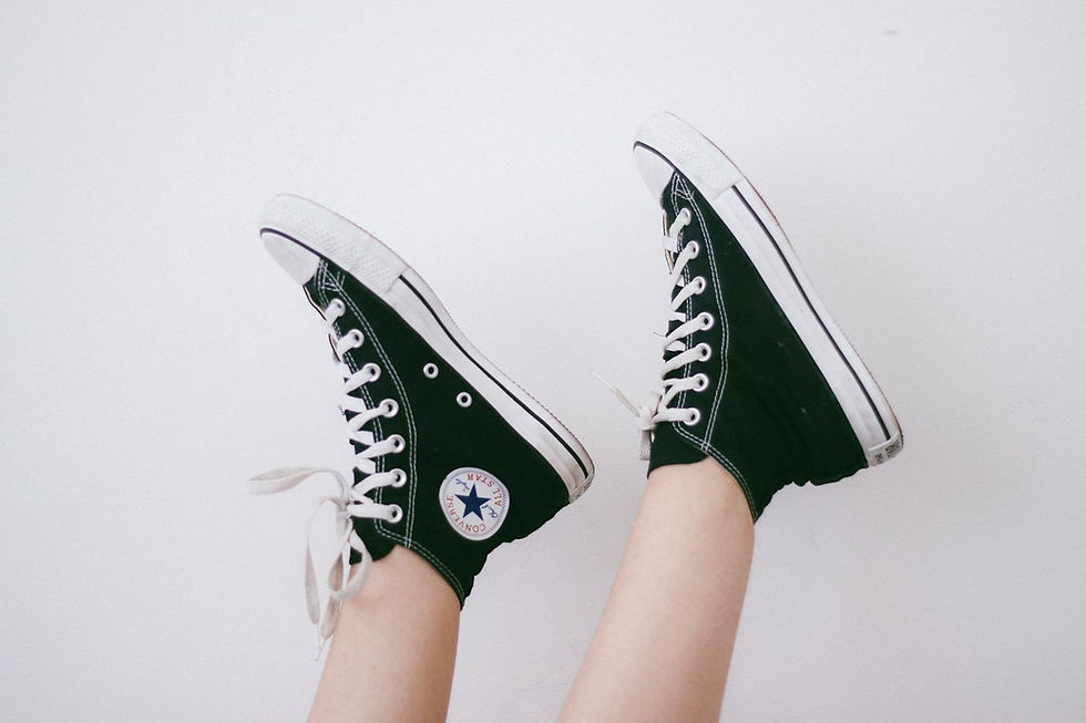Converse Chuck Taylor high-top sneakers worn with bare ankles