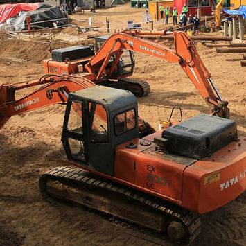 Two orange excavators on a construction site
