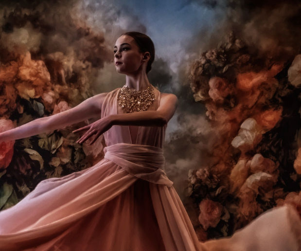 an elegant portrait of a dancer in motion, dancing against a background of magnificent flowers