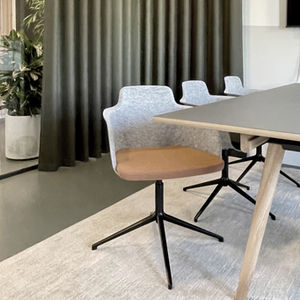 et mødelokale med stole, tæppe og bord og gardiner