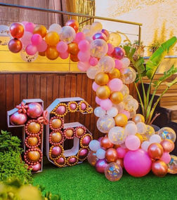 Radiant celebrations with LuxuryEventsBcn. Behold a vibrant balloon arrangement in an array of colors, casting a festive atmosphere. Below, two colossal numbers, 1 and 6, intertwine to signify the joyous milestone of '16,' each number filled with an assortment of balloons, promising a lively and memorable event.