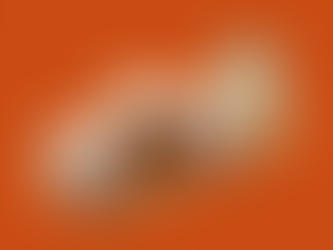 Bath and facial scrubs resting on a wooden tray with a candle