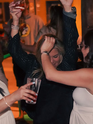 Lively indoor gathering at Jefe Cigar Lounge's karaoke night in New Smyrna Beach, Florida. Guests dance and enjoy drinks in a vibrant atmosphere