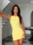 Woman with dark hair in a fitted yellow dress