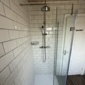 Walk-in shower with white metro tiles and glass screen