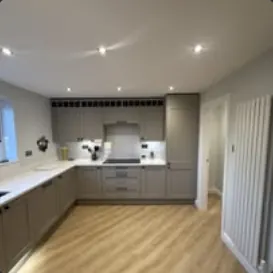 L-shaped kitchen with grey shaker units and white worktops
