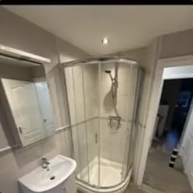 Bathroom with quadrant shower enclosure and basin