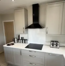 Kitchen with shaker units, black chimney extractor and white worktops